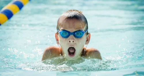 ein Junge hat Schwimmunterricht in der Grundschule