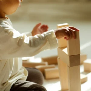 Kind spielt mit Holzkloetzen